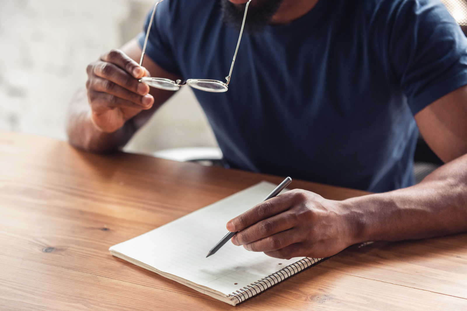 Man writing in a journal while at home in the new normal