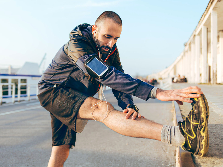 Man runner stretching legs preparing for run training 