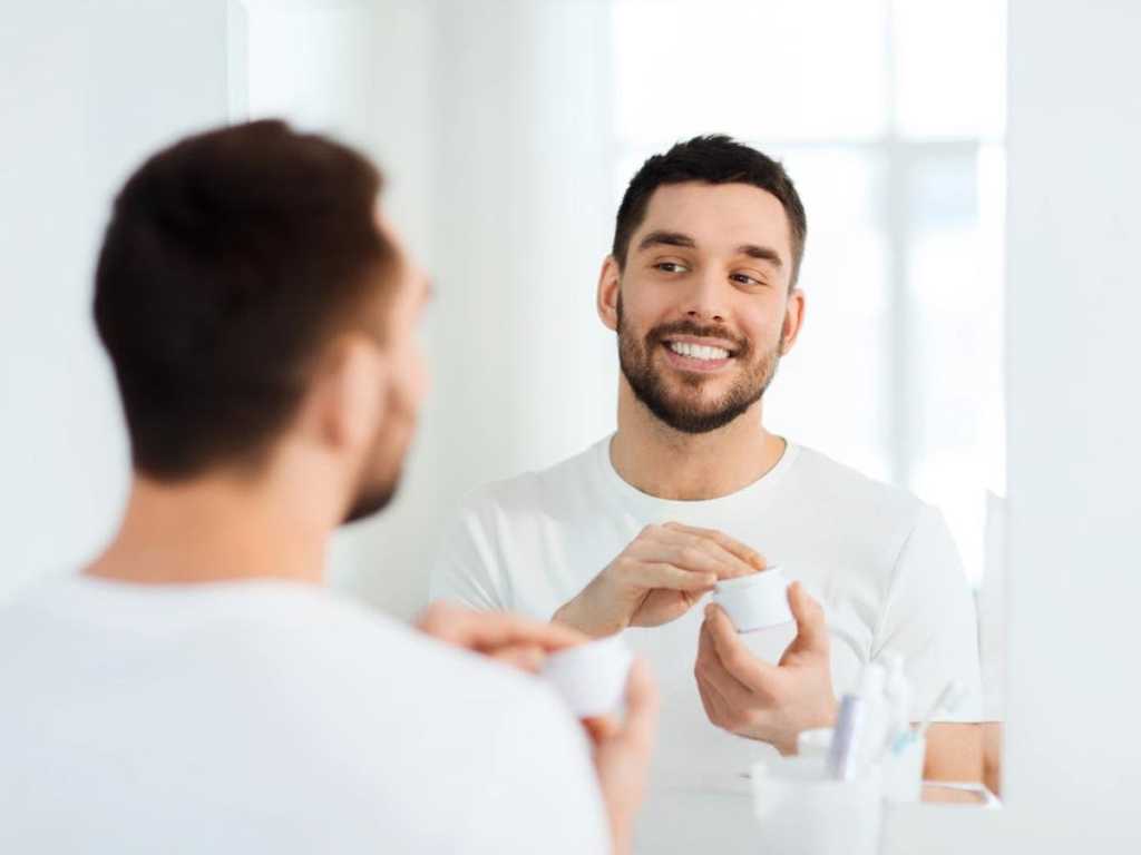 Man taking Moisturizer on face