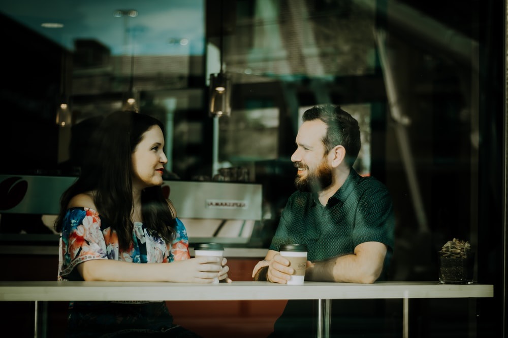 Adult couple talking at a table in a coffee shop 