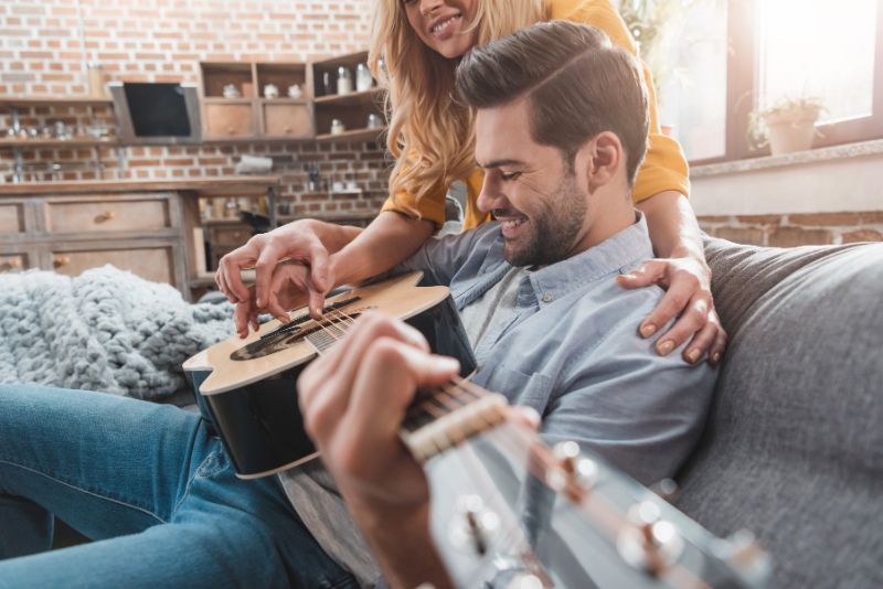 close-up shot of happy young couple playing guitar together 