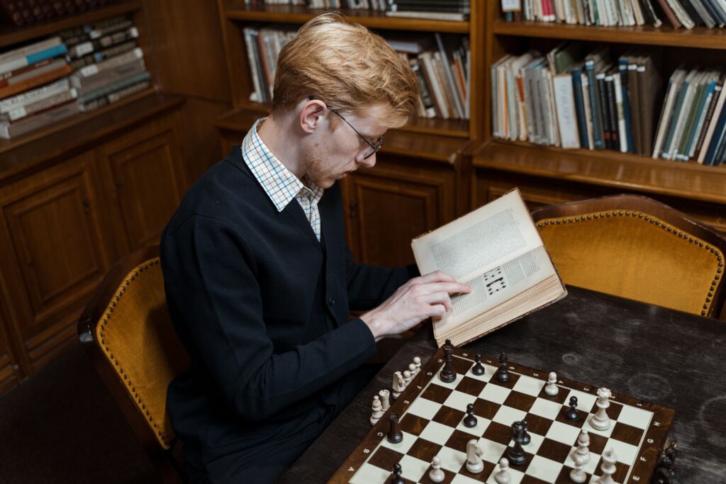 Man Reading a Book Inside the Library 