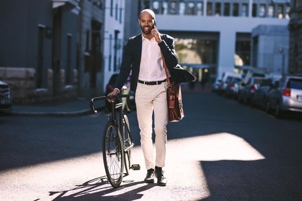 man walking with bicycle to work 