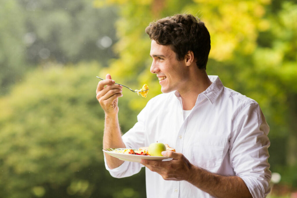 handsome young man eating scrambled egg for breakfast