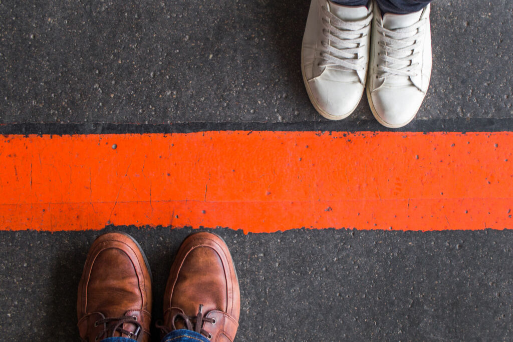 Man and woman standing opposite each other on either side of the road