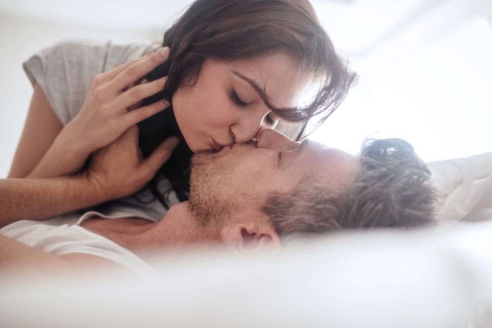 couple being romantic and kissing in bed 