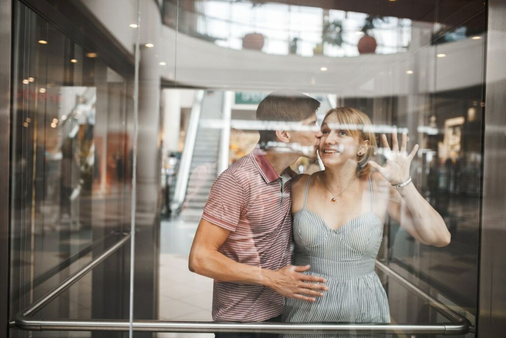 Romantic man kissing his girlfriend in an elevator 